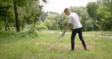 Çocuk gönüllü olarak parktan çöp topluyor.
