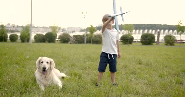 Lindo chico jugando con avión de juguete en el parque — Vídeos de Stock