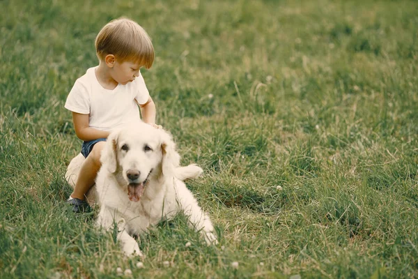 Kleine jongen spelen met zijn hond op een gras — Stockfoto