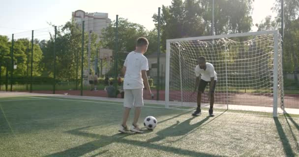Hombre deportivo jugando al fútbol con un niño preadolescente — Vídeos de Stock