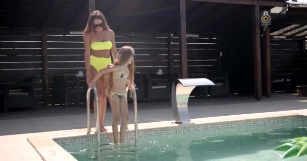 Madre e hija pasando junto a la piscina — Vídeos de Stock