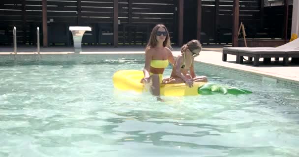 Mère et fille avec matelas gonflable en ananas dans la piscine — Video