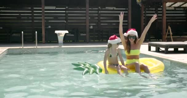 Mère et fille dans les chapeaux de Noël dans la piscine — Video