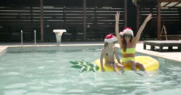 Mãe e filha em chapéus de Natal na piscina — Vídeo de Stock