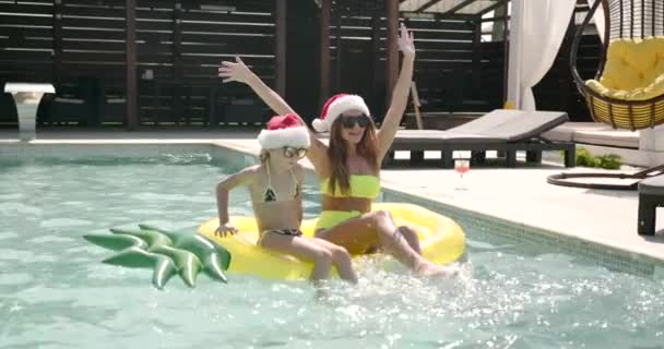 수영장에서 크리스마스 모자를 쓴 엄마와 딸 — 비디오