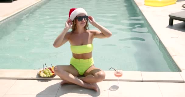 Mulher em santa chapéu comemorar o Natal na piscina — Vídeo de Stock