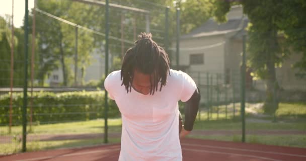Hombre afroamericano hace un calentamiento antes de jugar baloncesto — Vídeo de stock