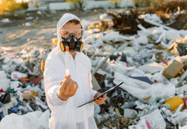 Plastik atık alanı araştıran araştırmacı çevre kirliliği seviyesini analiz ediyor