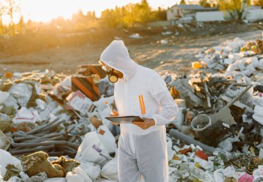 Plastik atık alanı araştıran araştırmacı çevre kirliliği seviyesini analiz ediyor