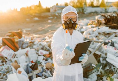 Plastik atık alanı araştıran araştırmacı çevre kirliliği seviyesini analiz ediyor