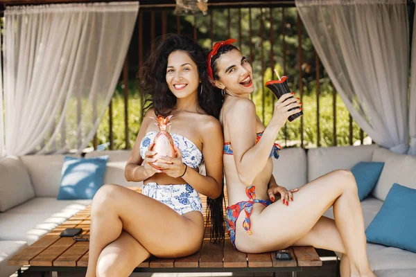 방갈로에 앉아 있는 수영복을 입은 두 소녀의 모습 — 스톡 사진