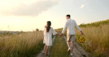 Oğlu olan genç bir aile yazın olgun buğday tarlalarında yürür.