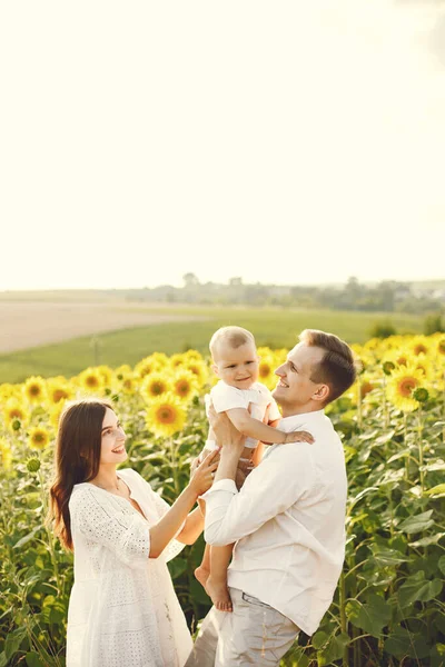 Mère, père et fils en vêtements blancs au champ de tournesols — Photo