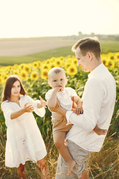 Matka, otec a syn v bílých šatech na slunečnicovém poli — Stock fotografie