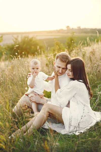 Mutter, Vater und Sohn in weißen Kleidern posieren auf dem Feld für ein Foto — Stockfoto