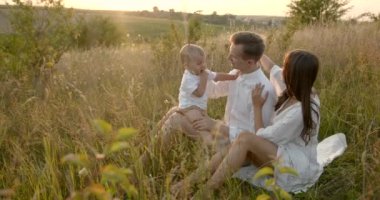Oğlu çayırda dinlenen genç bir aile.