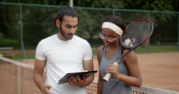 Černá žena tenista a trenér na tenisovém kurtu — Stock video