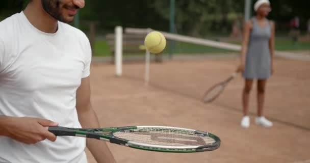 Onherkenbare man stuitert een bal op tennisracket — Stockvideo
