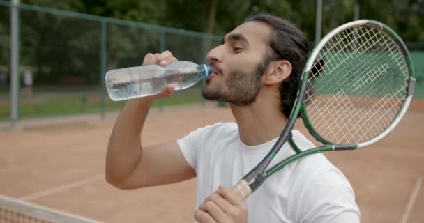 Όμορφος κουρασμένος τενίστας με νερό στο γήπεδο τένις — Αρχείο Βίντεο