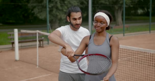 Mężczyzna instruktor uczy młody kobieta grać w tenisa — Wideo stockowe