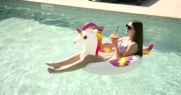 Jovem se divertindo no anel inflável em uma piscina — Vídeo de Stock