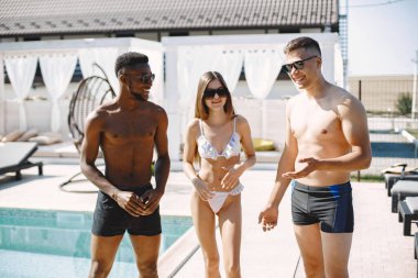 Mayolu üç arkadaş sahilde dikiliyor.