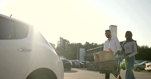 Africký arabský pár balení potraviny v autě — Stock video