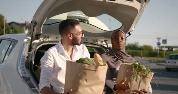 Různé páry s potravinami v papírových sáčcích v kufru auta — Stock video
