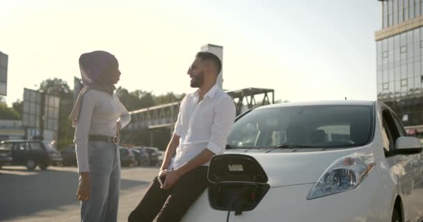 Mladý pár nabíjení elektrické auto na stanici — Stock video