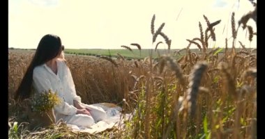 Güzel anne ve kız gün batımında buğday tarlasında eğleniyorlar.