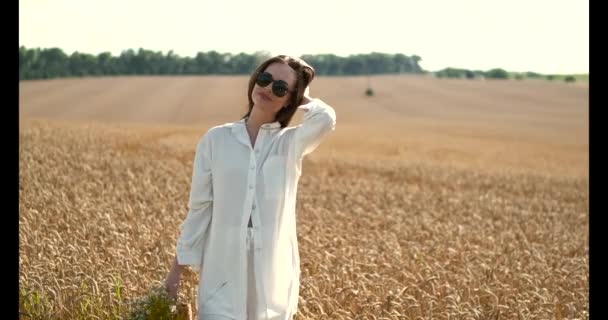 Красивые каштановые волосы молодая женщина на летнем пшеничном поле — стоковое видео
