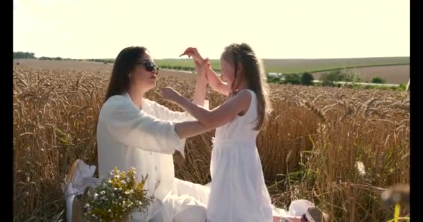 Belle mère et fille s'amusent dans un champ de blé au coucher du soleil — Video