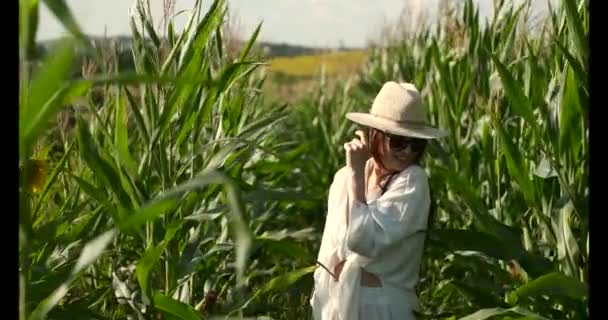 Ładna młoda kobieta ciesząca się słońcem na polu kukurydzy — Wideo stockowe
