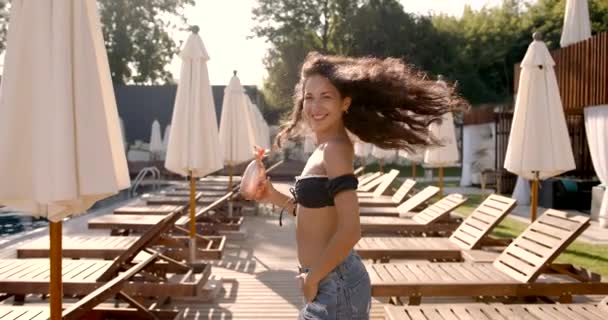 Młoda kobieta fit gospodarstwa koktajl spacery przy basenie — Wideo stockowe