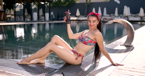 Atractivas mujeres jóvenes en bikini tumbadas en la terraza cerca de la piscina — Vídeos de Stock