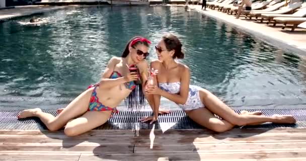 Dos amigas relajándose junto a la piscina en verano — Vídeos de Stock