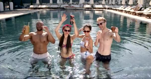Щасливі багаторасові друзі розважаються на вечірці біля басейну у відпустці — стокове відео