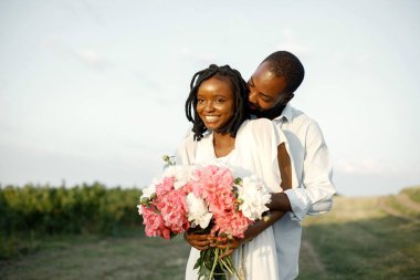 Mutlu romantik çift yaz tarlasında sarılıyor.