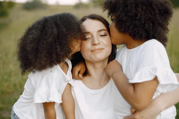 Mère caucasienne est embrassée par ses filles de race mixte — Photo