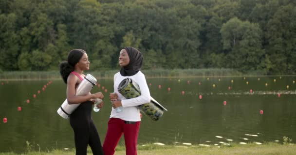 Kvinnliga vänner med sportutrustning som pratar utomhus — Stockvideo