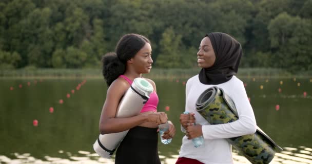 Kvinnliga vänner med sportutrustning som pratar utomhus — Stockvideo