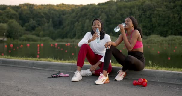 Negro amigas teniendo un descanso después de trotar — Vídeos de Stock