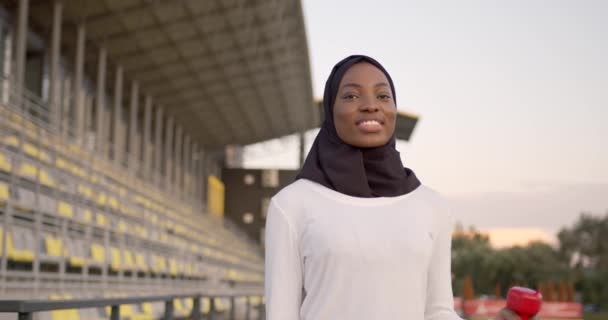 Чорношкіра мусульманка вправа з гантелями на відкритому повітрі — стокове відео