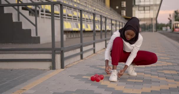 Donna nera musulmana che mette i lacci allo stadio — Video Stock