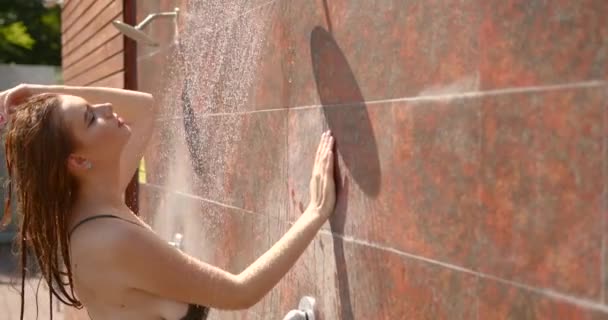 A girl is taking shower after sunbathing outdoors — Stock Video