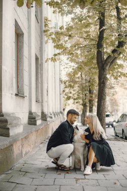 Sokakta köpek gezdiren şık bir çift.