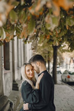 Mutlu genç çift dışarıda sarılıp öpüşüyor.