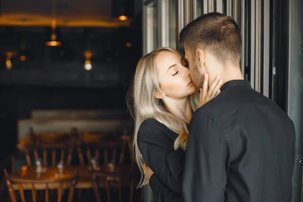 Романтическая молодая пара обнимается у окна кафе — стоковое фото