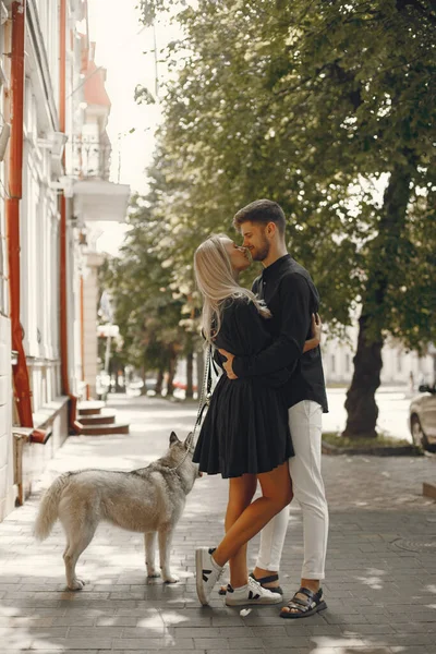 Jong stijlvol paar wandelen met hond in straat — Stockfoto