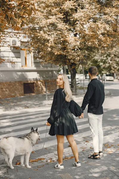 Giovane coppia elegante a piedi con cane in strada — Foto Stock